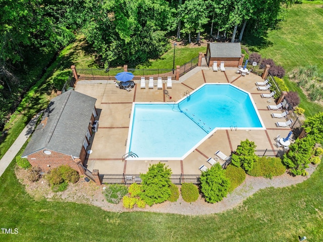community pool featuring fence, a patio, and a lawn