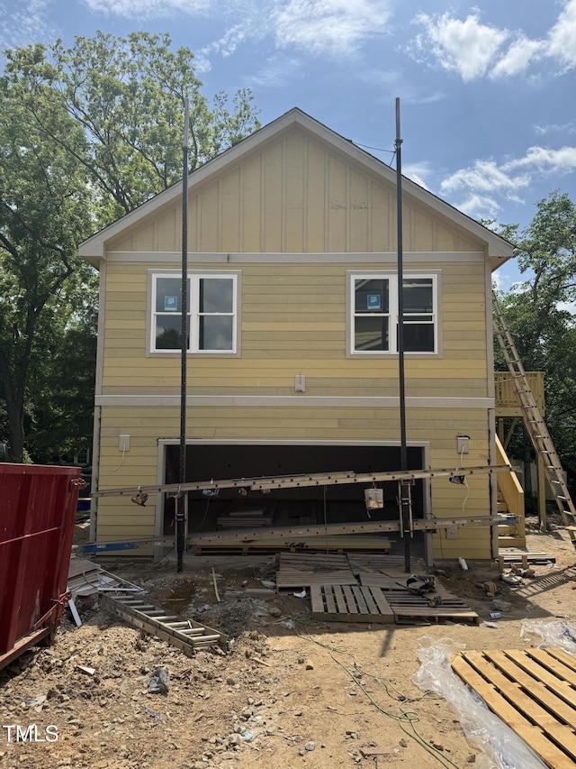 back of house with board and batten siding and stairway