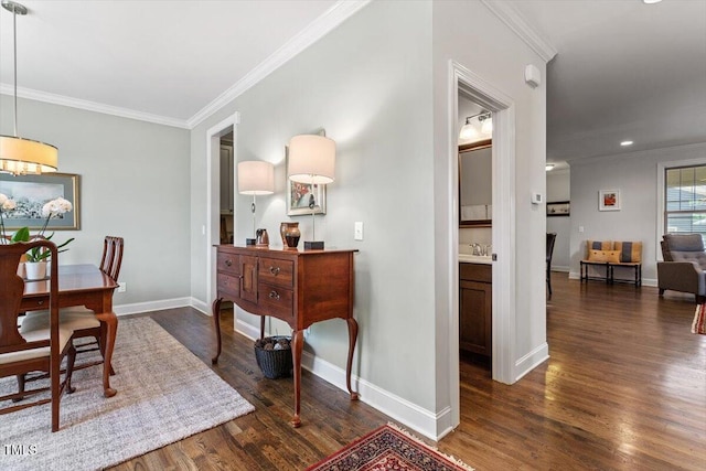 dining area featuring baseboards, ornamental molding, and wood finished floors