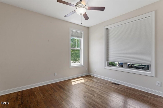 unfurnished room featuring a ceiling fan, baseboards, visible vents, and wood finished floors