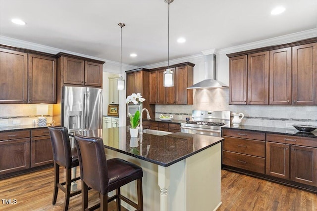 kitchen featuring wall chimney range hood, tasteful backsplash, a sink, ornamental molding, and stainless steel appliances