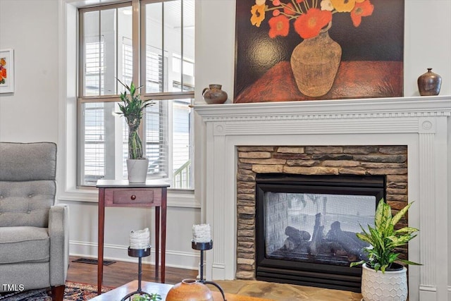 details with baseboards, a fireplace, and wood finished floors