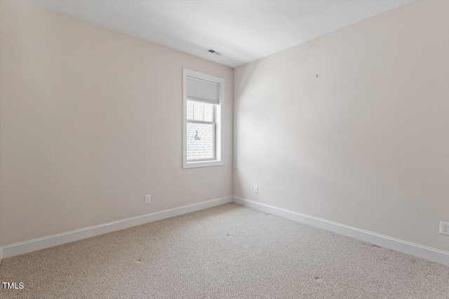 spare room with visible vents, baseboards, and light carpet