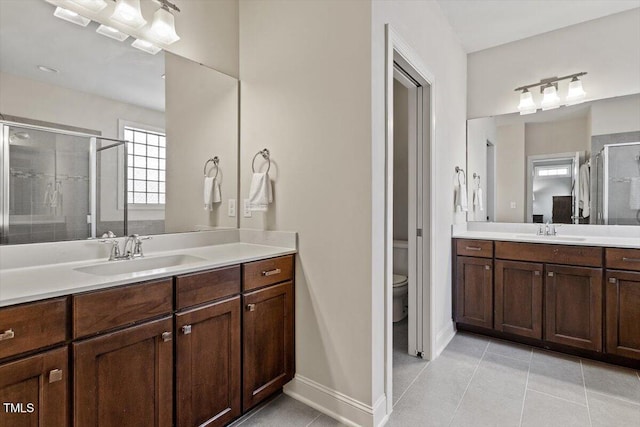 full bath with a sink, a stall shower, toilet, and tile patterned floors