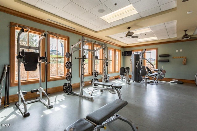workout area featuring baseboards, a ceiling fan, and a drop ceiling