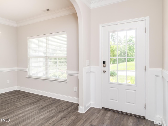 doorway with arched walkways, ornamental molding, visible vents, and dark wood-type flooring