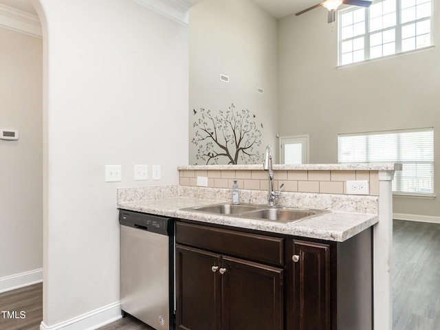 kitchen featuring a sink, ceiling fan, dark wood-style floors, stainless steel dishwasher, and dark brown cabinets