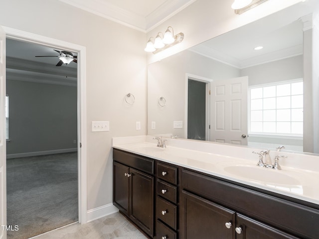 bathroom featuring ceiling fan, ornamental molding, double vanity, and a sink