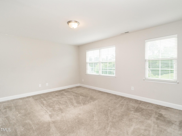 carpeted spare room featuring baseboards