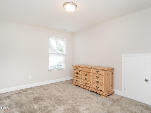 bedroom with baseboards and light carpet