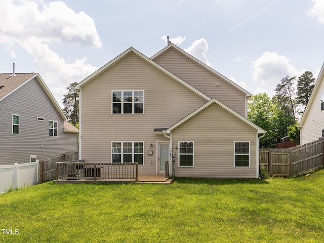 rear view of property with a wooden deck, a lawn, and a fenced backyard