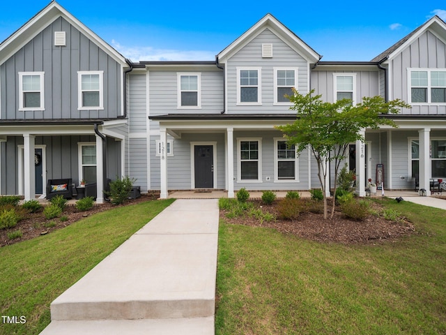 1218 S Franklin St, Wake Forest, NC 27587 - townhome / multi-family property featuring board and batten siding, a porch, and a front lawn
