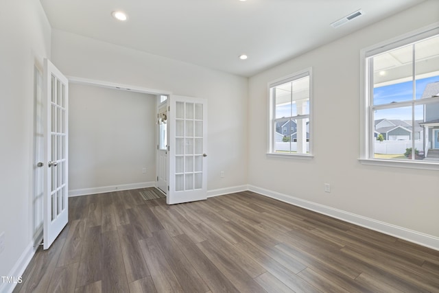 empty room with baseboards, dark wood finished floors, french doors, and visible vents