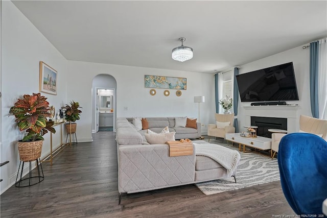 6528 Carswell Dr, Fayetteville, NC 28311 - living room with arched walkways, baseboards, and wood finished floors