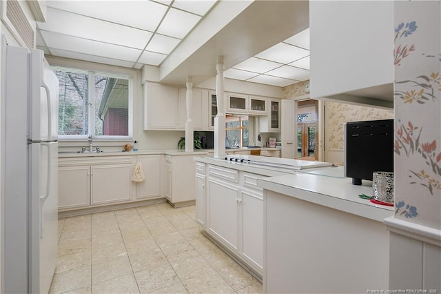 219 Devane St, Fayetteville, NC 28305 - kitchen featuring freestanding refrigerator, light countertops, a paneled ceiling, white cabinetry, and a sink