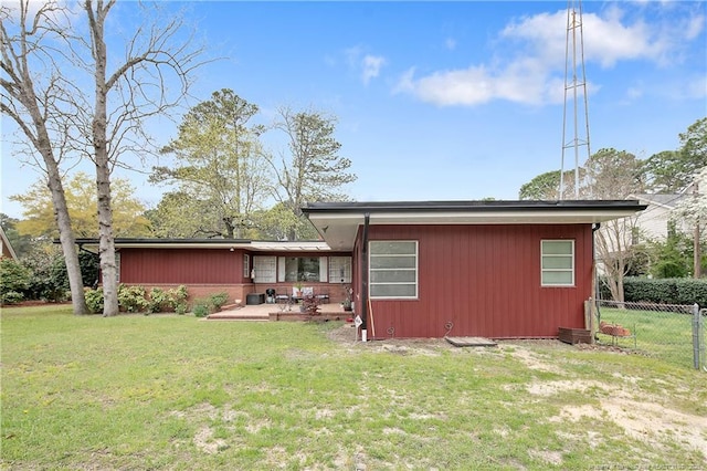 rear view of house with fence, a patio, and a yard