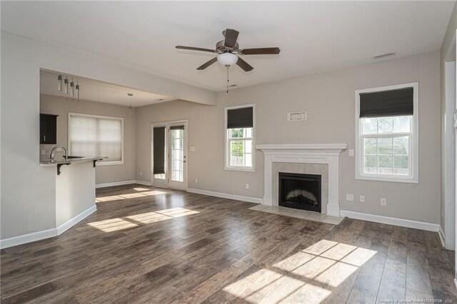 2109 Stonewash Dr, Fayetteville, NC 28306 - unfurnished living room featuring ceiling fan, dark wood finished floors, baseboards, a tile fireplace, and visible vents
