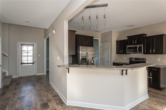 2109 Stonewash Dr, Fayetteville, NC 28306 - kitchen featuring backsplash, stainless steel appliances, light stone countertops, and wood finished floors