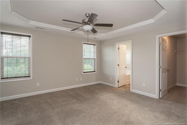 2109 Stonewash Dr, Fayetteville, NC 28306 - unfurnished bedroom with crown molding, a walk in closet, a raised ceiling, carpet floors, and visible vents