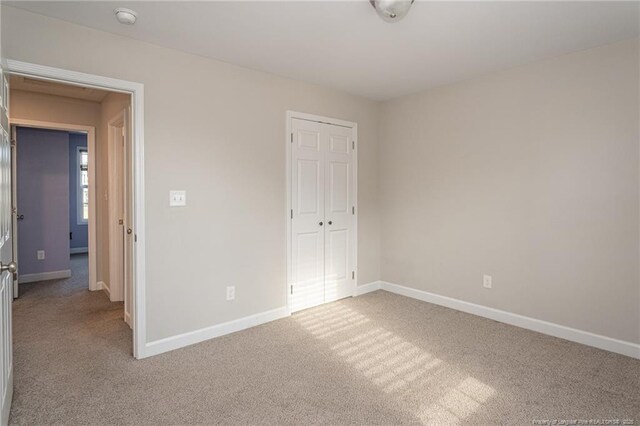 2109 Stonewash Dr, Fayetteville, NC 28306 - unfurnished bedroom featuring baseboards, a closet, and light colored carpet