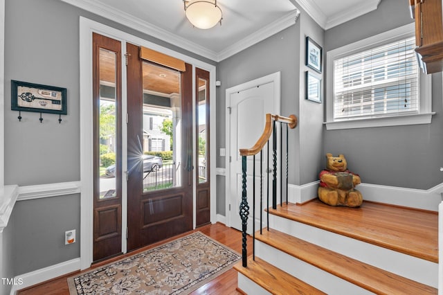 entrance foyer featuring wood finished floors, a healthy amount of sunlight, and stairway