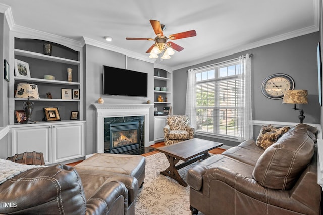 living area with crown molding, a ceiling fan, and a fireplace