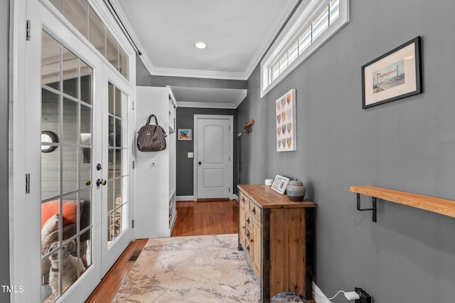 interior space featuring french doors, recessed lighting, baseboards, wood finished floors, and ornamental molding