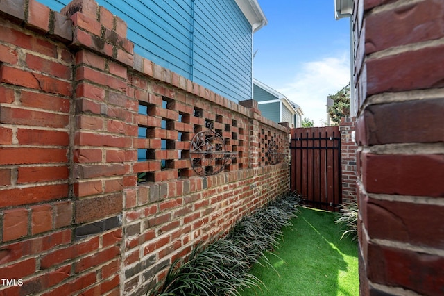 view of home's exterior with brick siding and fence