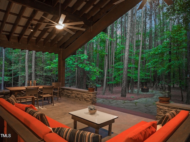 view of patio with outdoor lounge area, outdoor dining space, ceiling fan, and a wooded view