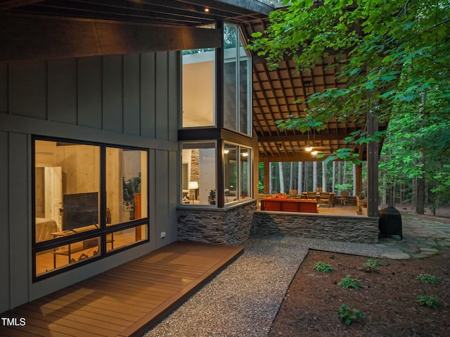 back of property with board and batten siding and a patio area