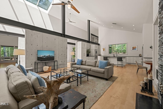living area featuring high vaulted ceiling, light wood-style floors, ceiling fan, and recessed lighting