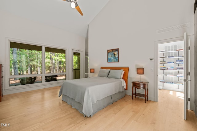 bedroom featuring high vaulted ceiling, multiple windows, light wood-type flooring, and ceiling fan