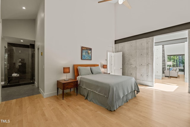 bedroom with a high ceiling, light wood-style floors, baseboards, recessed lighting, and ceiling fan