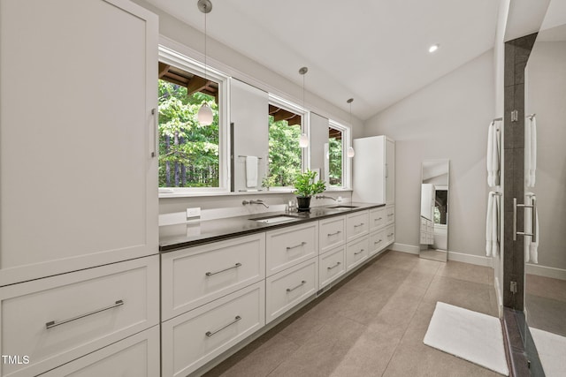 bathroom featuring vanity, tile patterned flooring, a shower with door, baseboards, and high vaulted ceiling