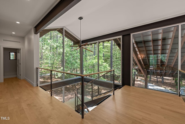 corridor with baseboards, wood finished floors, and recessed lighting