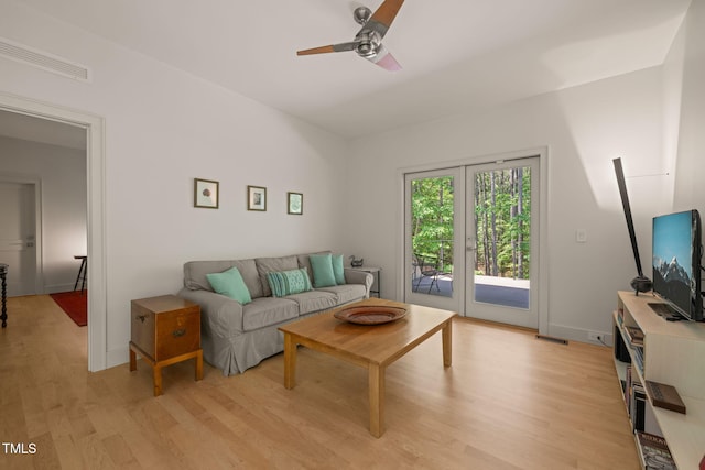 living room featuring light wood finished floors, ceiling fan, and baseboards