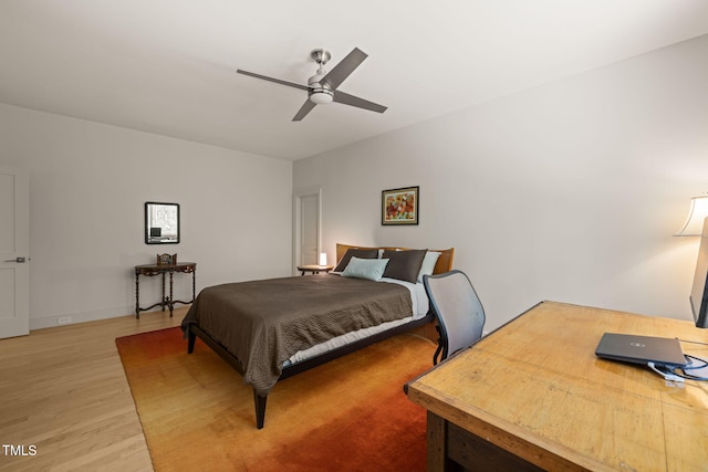 bedroom with light wood finished floors, a desk, and ceiling fan