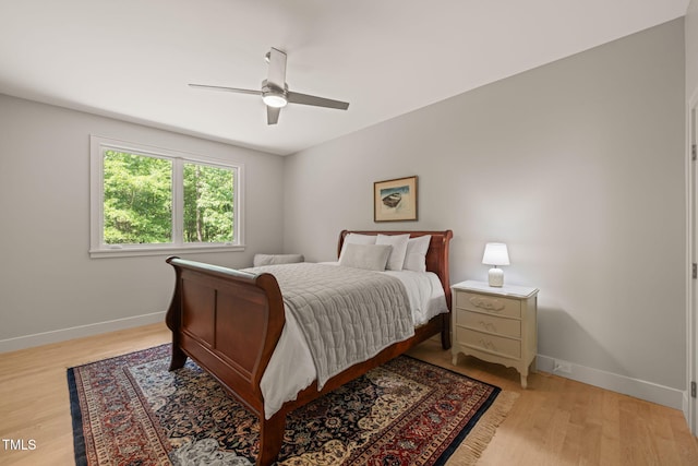 bedroom featuring baseboards, light wood-type flooring, and ceiling fan