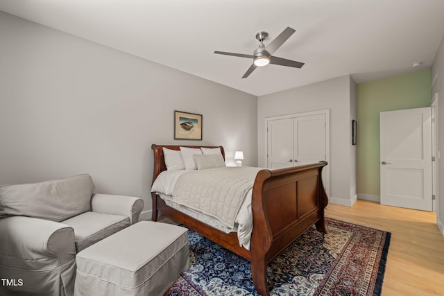 bedroom with light wood-style floors, baseboards, and ceiling fan