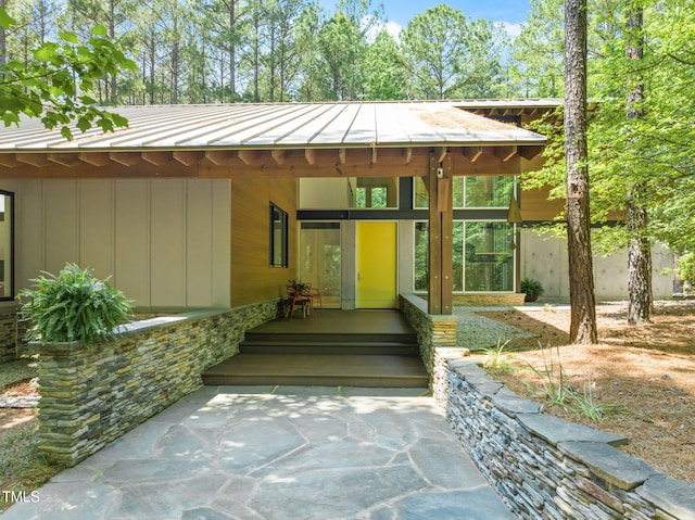 view of exterior entry with a standing seam roof and metal roof