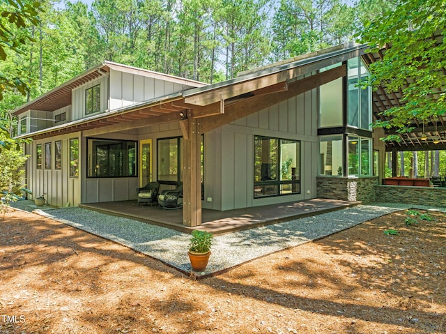 back of house featuring board and batten siding and a patio area