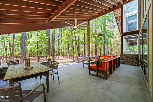 view of patio / terrace featuring outdoor dining space, an outdoor hangout area, and a forest view