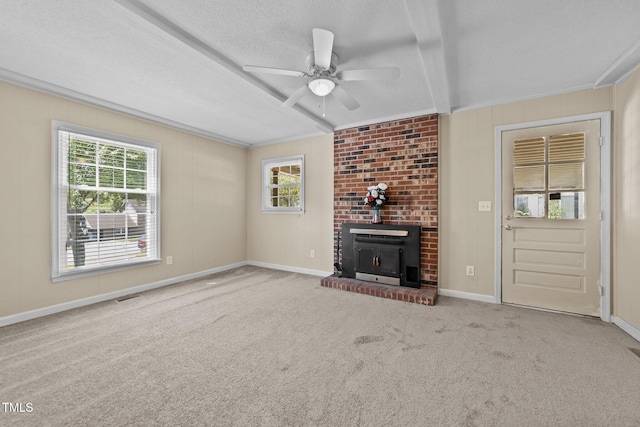 unfurnished living room featuring visible vents, beam ceiling, a fireplace, a textured ceiling, and a ceiling fan