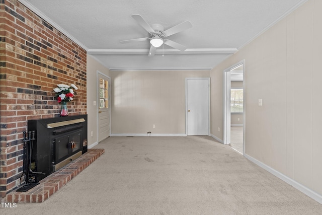 unfurnished living room featuring ceiling fan, ornamental molding, carpet flooring, and a textured ceiling