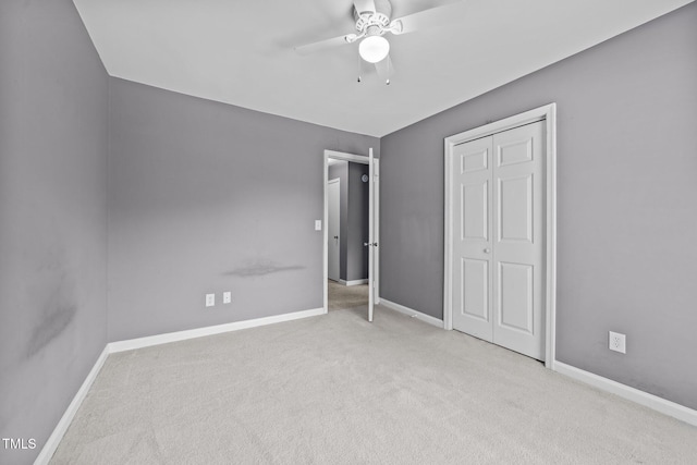 unfurnished bedroom with carpet floors, a ceiling fan, baseboards, and a closet