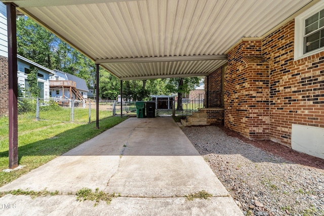 view of patio featuring fence, a gate, an attached carport, and driveway