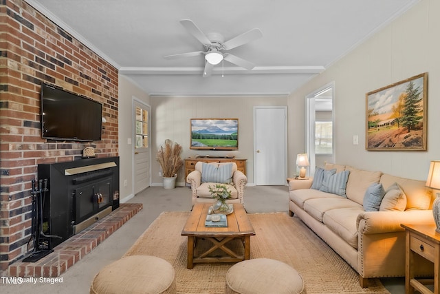 living room featuring crown molding, ceiling fan, and a fireplace