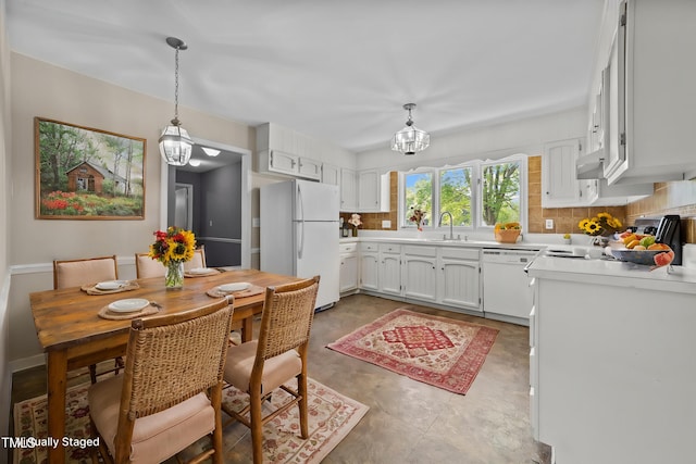 kitchen with white appliances, light countertops, a sink, and tasteful backsplash