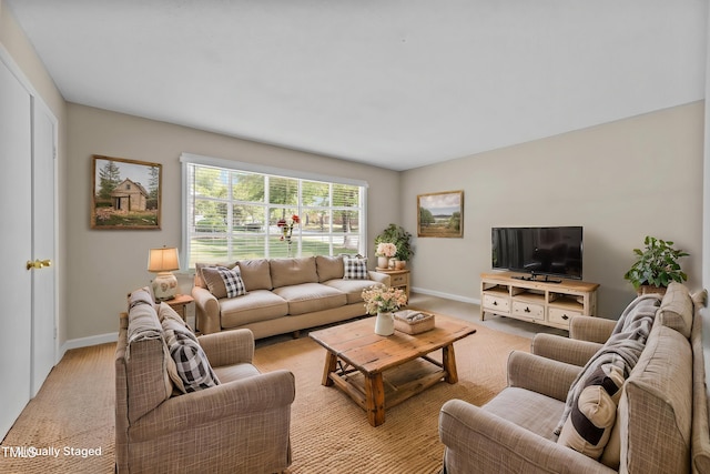 living room featuring baseboards and light carpet