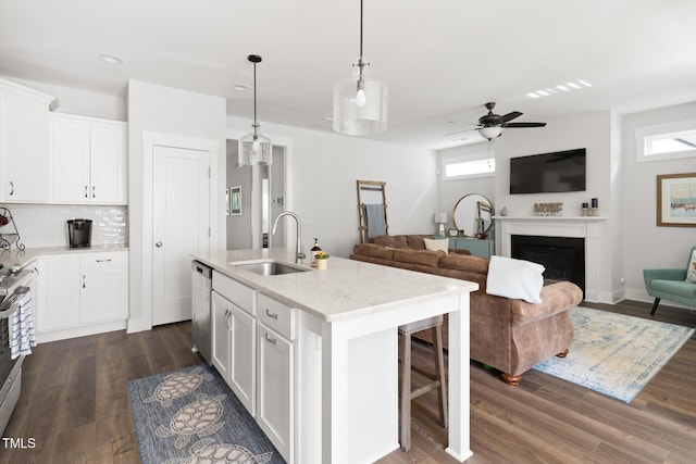 kitchen with a sink, white cabinetry, a ceiling fan, and open floor plan
